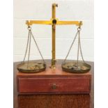 Set of Class B brass weighing scales on wooden box, with various weights