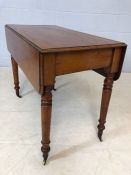 Mahogany drop leaf table on turned legs with original castors and hidden drawer, approx 90cm x