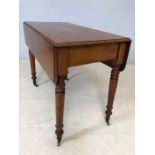 Mahogany drop leaf table on turned legs with original castors and hidden drawer, approx 90cm x
