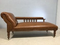 Newly upholstered chaise longue on oak frame with carved and stud detailing and on brass castors