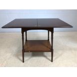 Small mahogany fold out games table on turned legs with shelf under