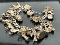 Silver charm bracelet with approx 20 charms mostly marked "silver" (approx 84g)