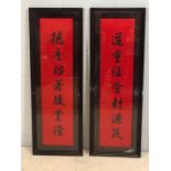Pair of Chinese black and red silk 'Good Luck' panels with ebonised frames, each approx 101cm x 25cm