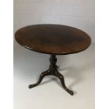 Mahogany circular tilt top table with brass fittings on tripod feet, diameter approx 75cm