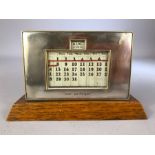 1930s perpetual calendar on wooden plinth with silver plate frame inscribed 'Lest we Forget', approx