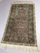 Hand stitched green ground silk rug, approx 157cm x 92cm