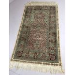 Hand stitched green ground silk rug, approx 157cm x 92cm