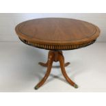Modern circular table on four curved legs with lion paw detailing to feet and two slim drawers,