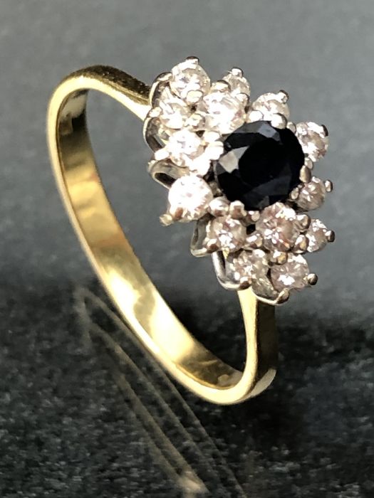 18ct 750 marked Gold ring set with fourteen diamonds surrounding a central Sapphire - Image 2 of 4