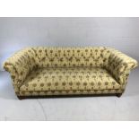 Chesterfield style three seater sofa with button back and plant design fabric upholstery, approx