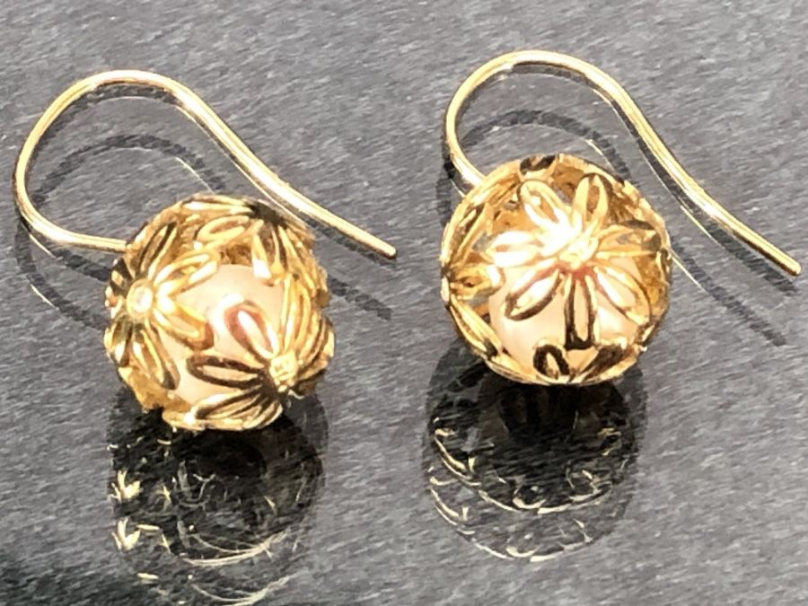 Pair of 9ct Gold earrings of delicate hollow gold balls set with diamonds and each encasing a