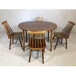 Mid Century circular dining table with drop leaves accompanied by four stick-back dining chairs