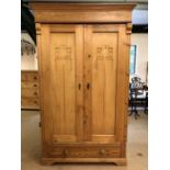 Pine wardrobe with two hanging rails and carved detail to doors, with key and drawer under, approx