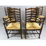 Set of six oak ladder back chairs with rush seats and turned stretchers, two carvers