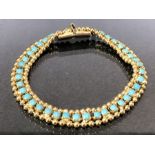 Gold coloured bracelet with gold beaded edge supporting Turquoise stones approx 18cm long