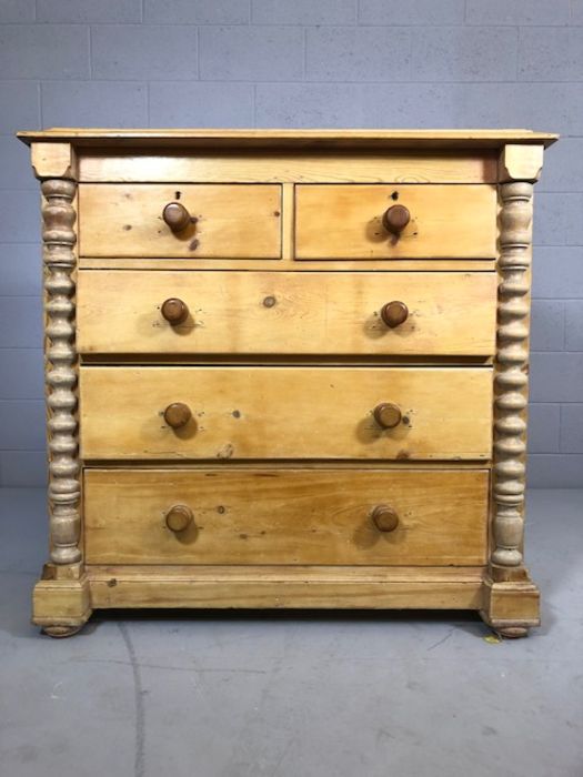 Pine chest of five drawers with turned columns to side on bun feet, approx 57cm x 115cm x 112cm