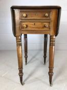 Drop leaf side table on turned legs with brass castors, two drawers and two faux drawers, approx