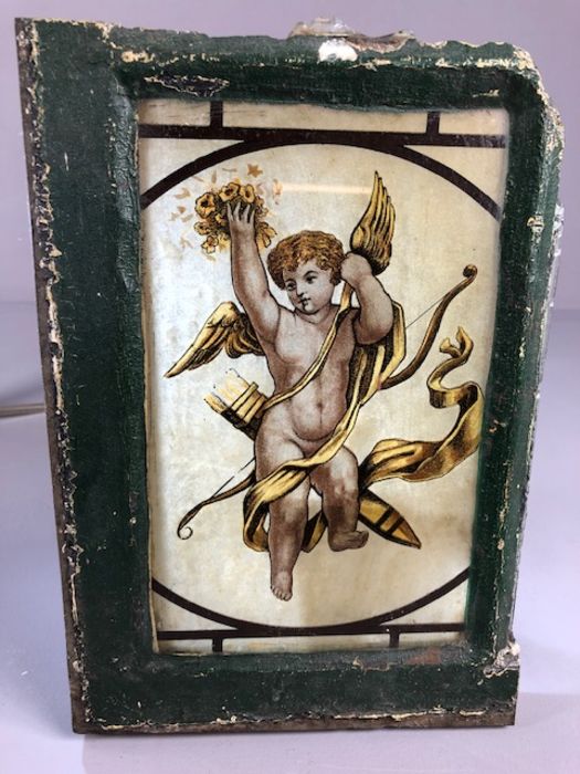 Section of a metal window containing a stained glass panel depicting a winged Cherub, approx 26cm