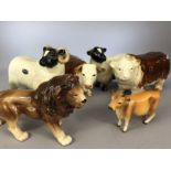 Five pieces of Cooperware to include bull (slight crack to foot) and cow, ram and sheep, a lion plus