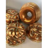 Collection of four copper jelly moulds of varying designs