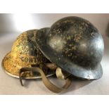 Two Military WWII helmets one marked for Plasfort and bakelite the other metal reads the other "
