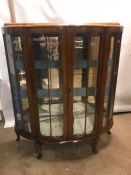 Serpentine fronted two door display cabinet with glass shelves and mirrored back