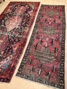 Two large red ground vintage woollen rugs, the first approx 310cm x 138cm, the second 280cm x