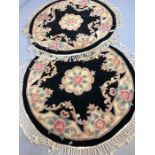 Pair of circular black ground woollen oriental rugs, approx 115cm in diameter