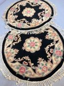 Pair of circular black ground woollen oriental rugs, approx 115cm in diameter