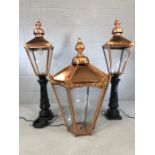 Three Victorian-style copper street lamps to include a smaller pair on black cast iron bases, each