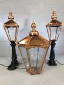 Three Victorian-style copper street lamps to include a smaller pair on black cast iron bases, each