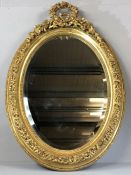 Oval Regency-style gilt framed bevel edged mirror with floral and beaded design, overall height