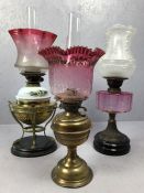 Three Victorian oil lamps, one with cranberry glass bowl (A/F)