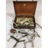 Equestrian interest; Collection of riding bits and stirrups in vintage case