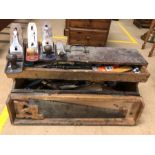 Collection of vintage woodworking tools including planes in a wooden carpenters box