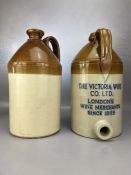 Two vintage cider flagons, one marked 'THE VICTORIA WINE CO. LTD. LONDON'S WINE MERCHANTS SINCE