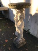 Stone birdbath supported by a figure of a child, approx 87cm in height