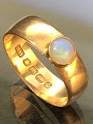 18ct Gold wide band fully hallmarked ring set with a single opal approx 4mm in diameter, size '