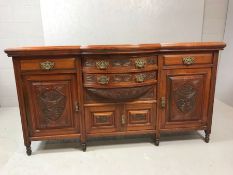 Heavily carved mahogany sideboard with brass handles, drawers and shelved cupboards, approx 184cm