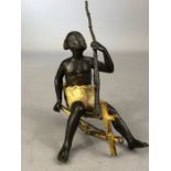 Cold painted bronze of a seated African man with a rifle, makers stamp to reverse