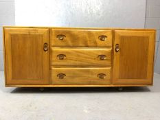 Ercol light elm sideboard with three central drawers (one with cutlery drawer) flanked by cupboards,