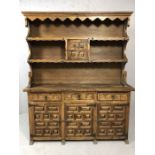 Heavily carved dresser with cupboards and three drawers under and shelves over, approx 150cm x