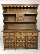 Heavily carved dresser with cupboards and three drawers under and shelves over, approx 150cm x