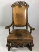 Heavily carved English oak and leather high back elbow chair with fleur de lis crest (A/F)