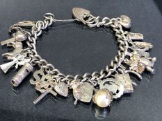 Silver Charm Bracelet with hallmarked silver heart shaped Lock and approx 18 silver and silver