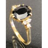 18ct Gold ring set with a large faceted Blue (Sapphire?) stone and three diamonds to each shoulder