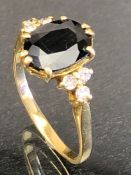 18ct Gold ring set with a large faceted Blue (Sapphire?) stone and three diamonds to each shoulder