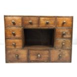 Antique pine set of eleven drawers with central aperture / shelf and turned handles, believed to