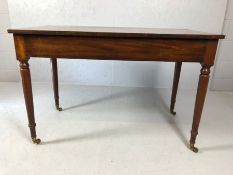 Mahogany table with single large drawer on turned and tapering legs with castors, approx 114cm x