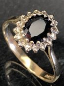 9ct Gold ring set with a large central red stone and surrounded by diamonds size 'Q'